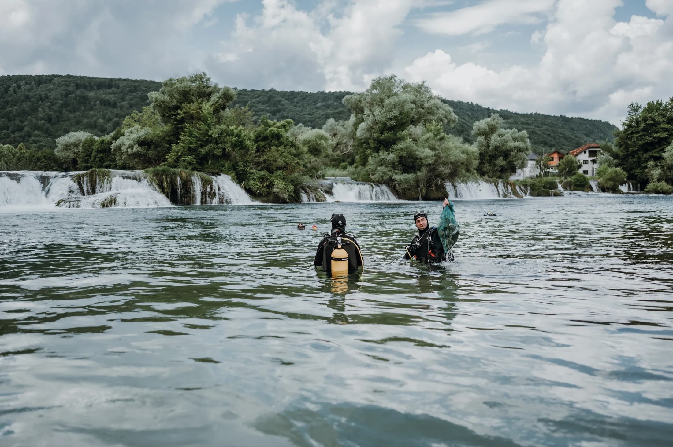 A diver in the Una River holding collected material during the cleanup action.