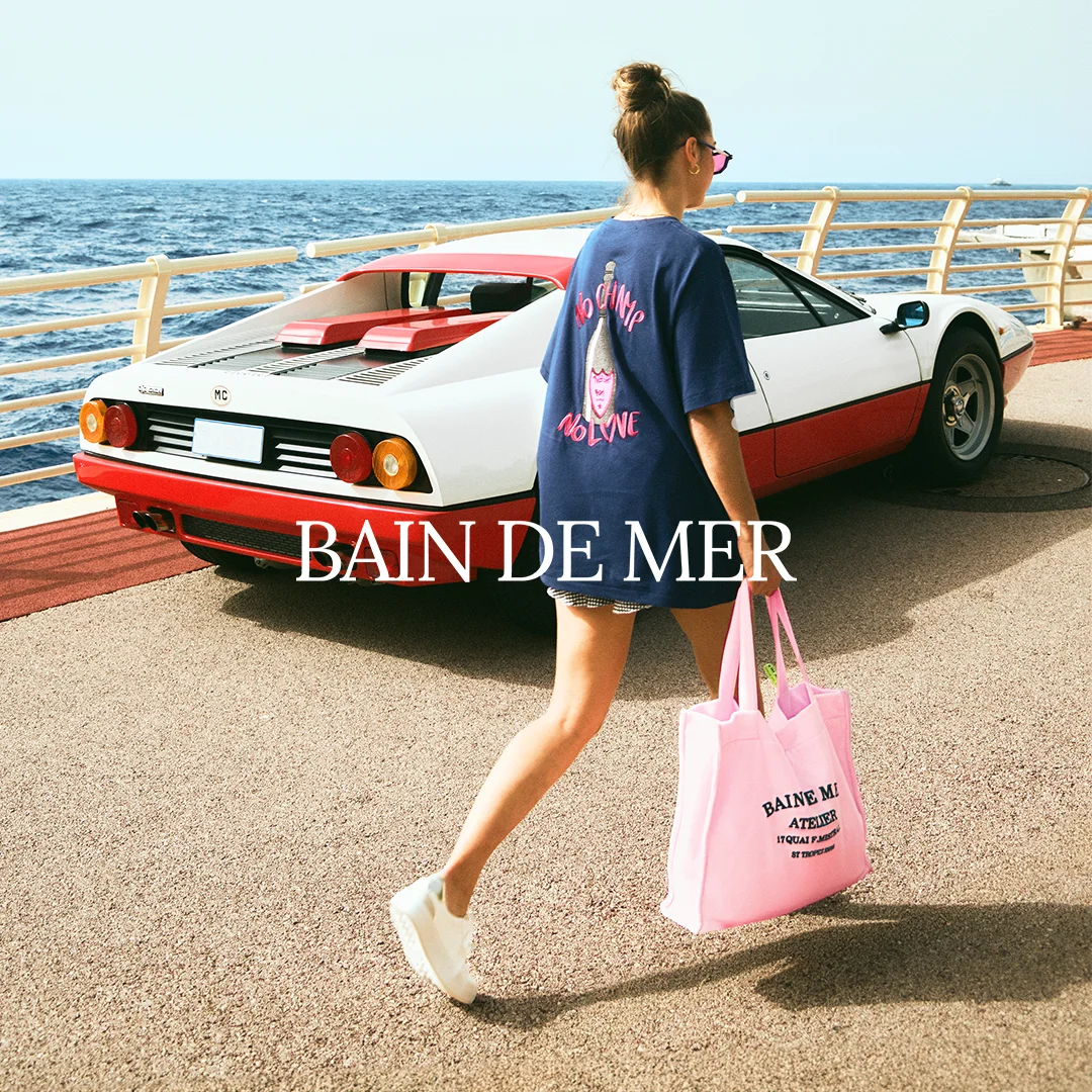 Los Angeles: a woman in a navy Bain de Mer tee walks past a white and red Ferrari carrying a pink Bain de Mer Atelier tote