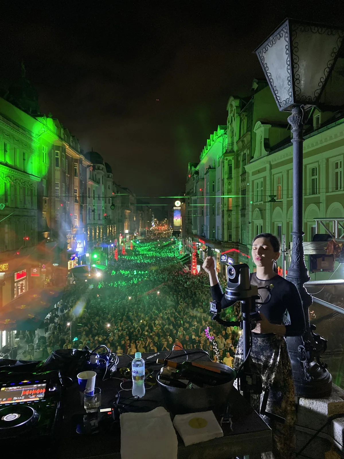 A DJ on a balcony above a Sarajevo street packed with a huge late-night crowd