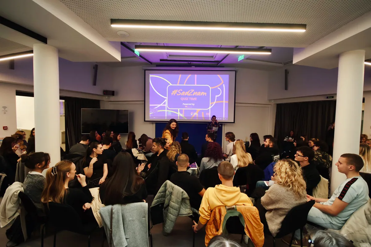 A crowded room at Europe House, people seated facing a screen.
